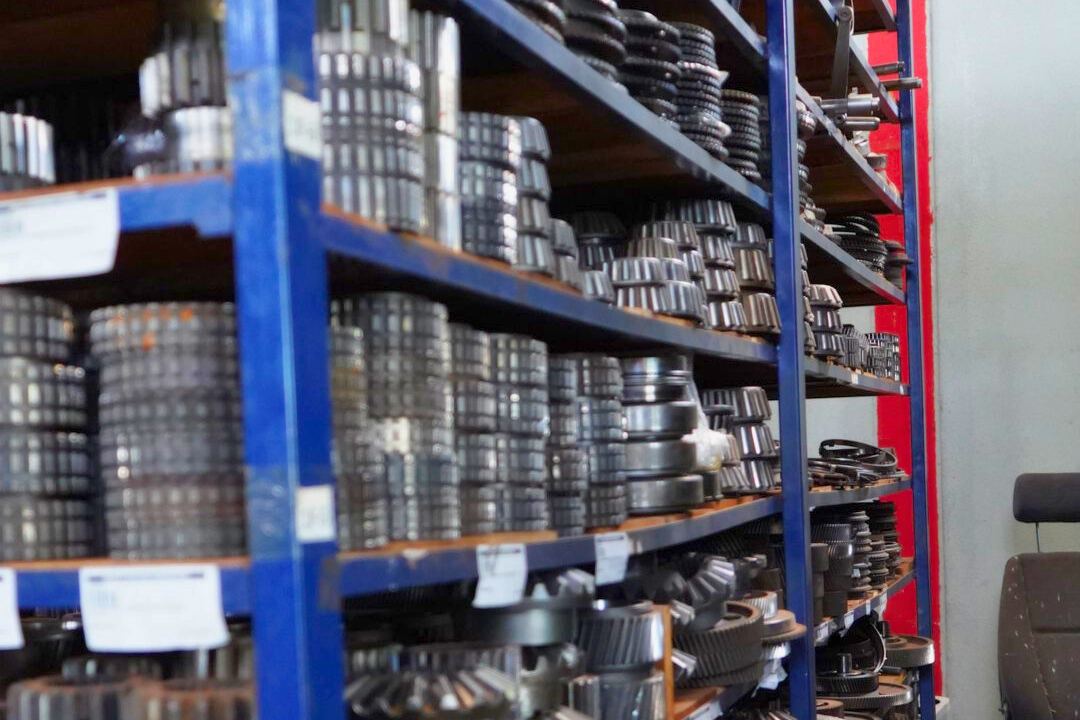 Estantes metálicos con engranajes y piezas de transmisión clasificadas en el depósito de semi nuevos